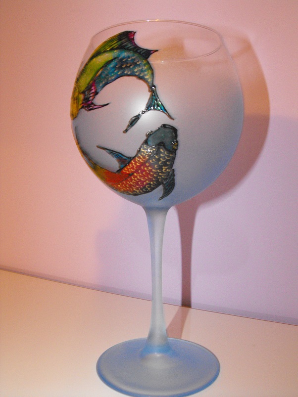 Ръчно рисувани стъклени чаши за червено вино и стъклен свещник с модив на зодиакален знак Риби. Можете да избирате изрисуването на различни символи, рисунки или вид на чашите, като можете да ги комбинирате с керамични чинии, гарафа, дървен поднос с декупаж, кана, пепелник или други материали по Ваш избор. Идеална комбинация за подарък за Вашия празник или Вашата трапеза. Можете да разгледате и други наши предложения като дървени кутии за бижута, ръчно рисувани шалове или някой от другите наши предложения.